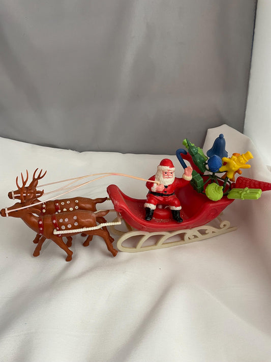 Vintage Plastic Santa claus With sled full of presents and his Reindeer Christmas decor.