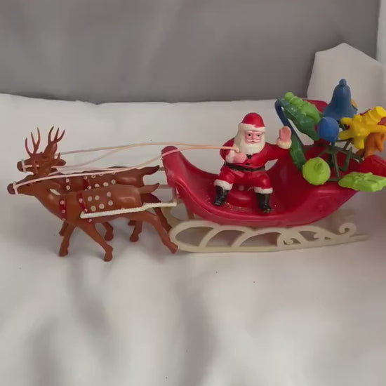 Vintage Plastic Santa claus With sled full of presents and his Reindeer Christmas decor.