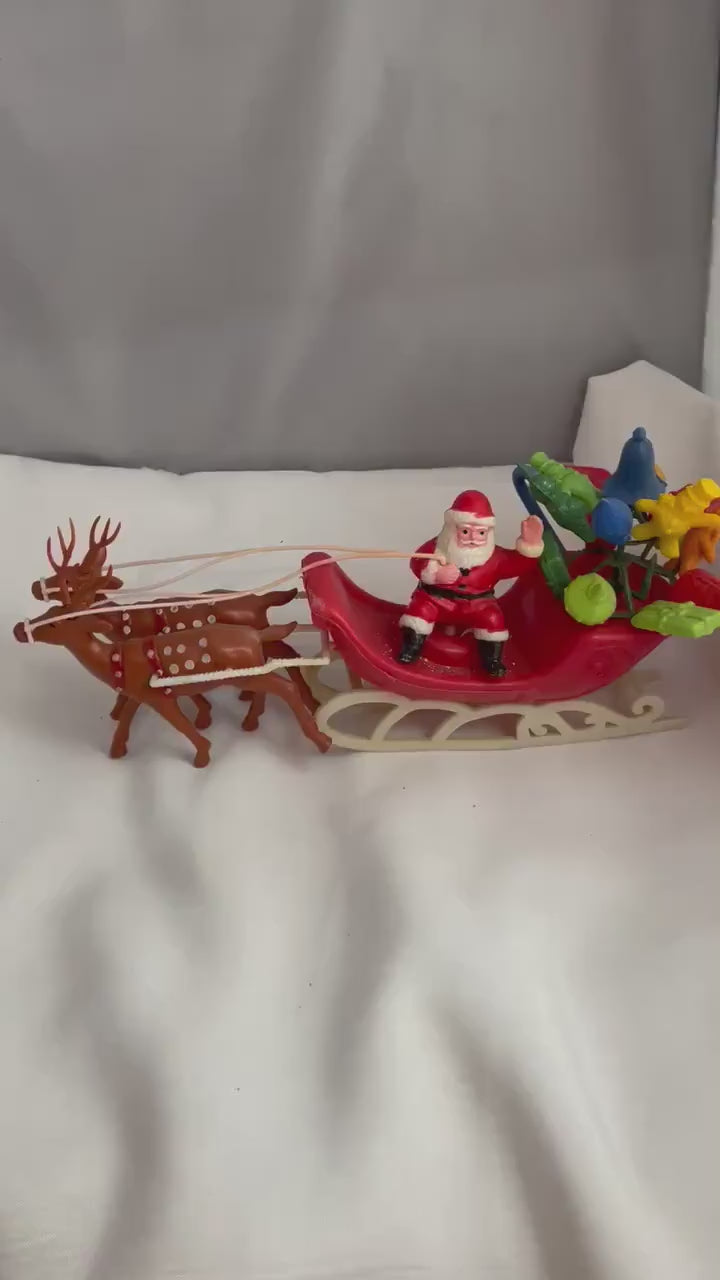 Vintage Plastic Santa claus With sled full of presents and his Reindeer Christmas decor.